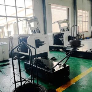 Industrial Workshop with White Manufacturing Machines Large Windows and Coils of Cable on Racks on a Green Floor