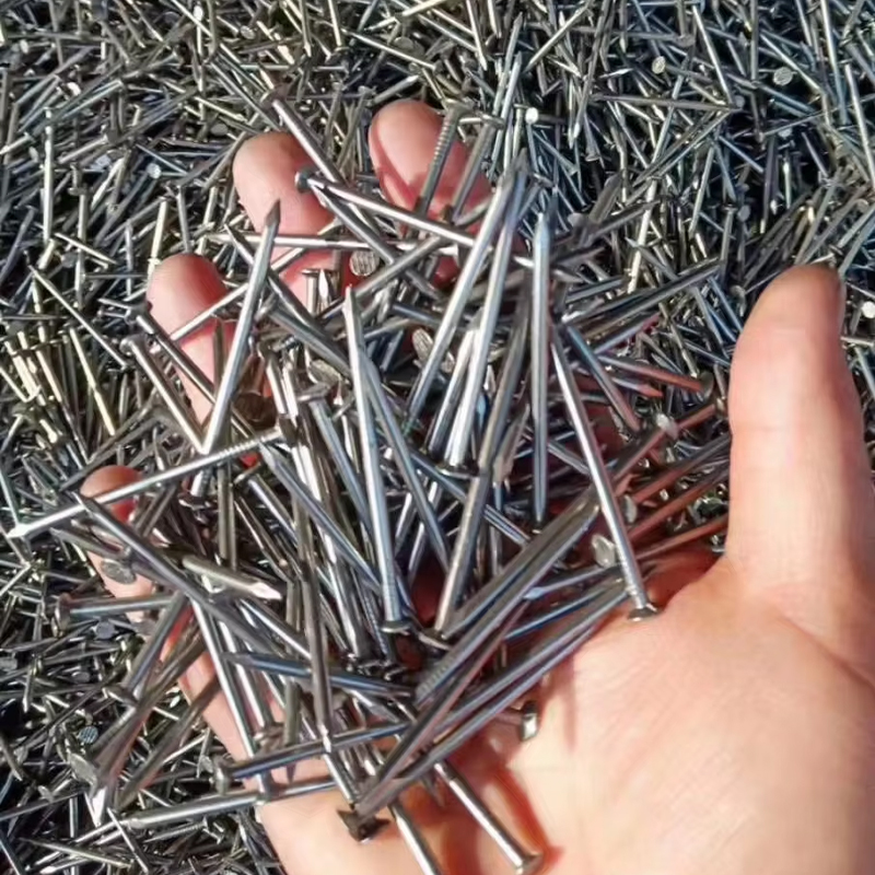 Close up of a Hand Cupping a Handful of Shiny Steel Nails