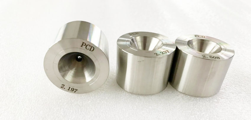PCD vs natural diamond die ND die - YF Metal Tech Three Shiny Metal Bushings of Varying Heights Arranged in a Row on a White Surface Each with an Inner Hole and Engraved Measurements eg 2197 2237 2508 and the Letters Pcd